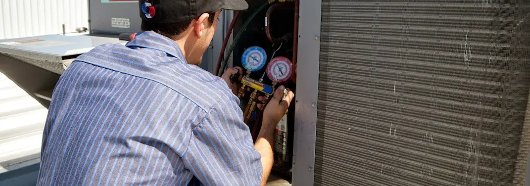 HVAC technician servicing a condenser unit in Happy Valley